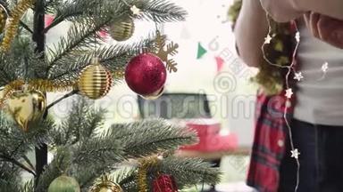 快乐的亚洲女人拿着圣诞装饰品在她的办公室装饰圣诞树。 漂亮的女人和她的朋友一起度假
